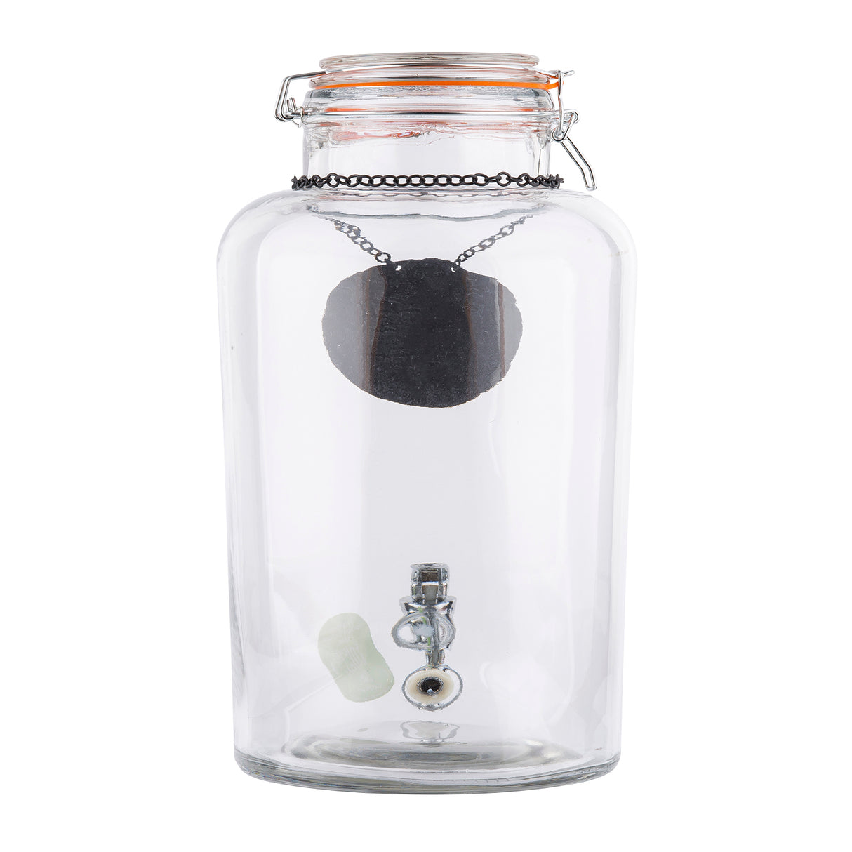 A clear glass beverage dispenser with a hinged lid contains a black pendant necklace hanging from the top. Inside, at the bottom, are a small white cylindrical object, a metal clasp, and an artificial eyeball. The background is plain white.