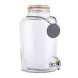 A large, clear 2.5 gallon beverage dispenser with a metal spigot and an orange-sealed lid. A blank, round black tag hangs from a chain around the neck of the jar, which is empty and set against a white background.