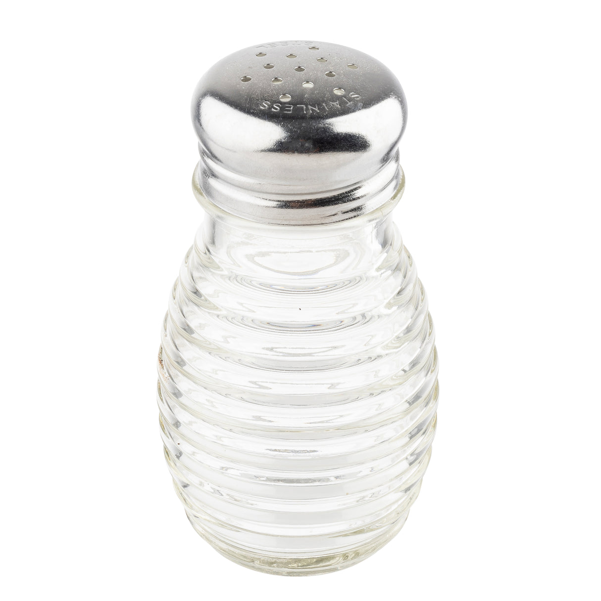 A clear, ribbed TableCraft glass salt shaker with a shiny metal lid featuring small holes for dispensing salt. “STAINLESS” is engraved on the lid. This beehive salt pepper shaker is empty and photographed against a plain white background.