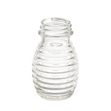 A clear, empty TableCraft glass bottle with a narrow neck and rounded body featuring evenly spaced horizontal ridges for a beehive-like look. Ideal as a replacement shaker for salt and pepper, it stands upright on a white background.