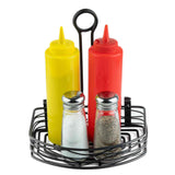 A black powder coated metal caddy holds a yellow squeeze bottle (mustard), a red squeeze bottle (ketchup), a glass salt shaker, and a glass pepper shaker. The bottles have pointed caps, the shakers have silver tops, and the background is white.