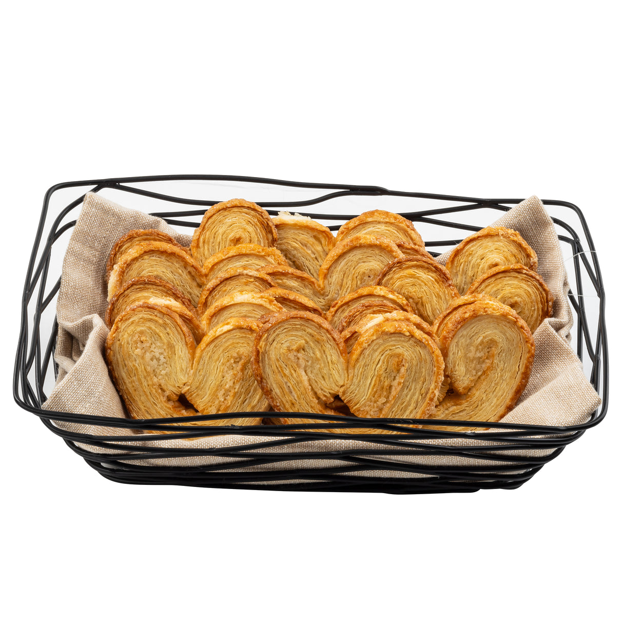 A black powder coated metal Artisan Collection Basket lined with beige fabric, filled with neatly arranged golden-brown puff pastry palmiers, displaying their distinctive heart-like spiral shapes.