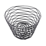 A black powder coated metal basket from the TableCraft BK17410 Artisan Collection, featuring an open, geometric design with concentric ovals and angled lines for a modern, airy look. The empty basket is photographed against a plain white background.