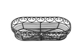 A black powder coated metal, oval-shaped wire basket from the Mediterranean Collection Basket by TableCraft. It features decorative swirls along the top and parallel metal bars at the bottom, set empty against a white background.