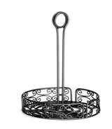 A black powder coated metal napkin holder with ornate scrollwork designs and a circular merchandising ring handle on top. This Mediterranean Versa Rack features an open side pattern and a tall central handle for easy carrying, set against a white background.