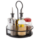 The Versa Rack round black metal caddy serves as a stylish shaker organizer, holding six spice jars: two tall glass bottles with metal spouts for oil and vinegar, plus four shorter shakers for salt, pepper, grated cheese, and red pepper flakes.