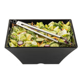 A rectangular black Frostone Collection Bowl filled with mixed salad greens, cucumber slices, red onion rings, and shredded carrots. Metal tongs rest on this dishwasher safe melamine bowl, photographed on a plain white background.