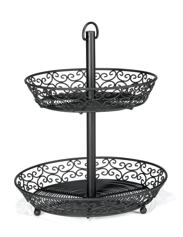 A two-tiered basket from our Mediterranean Collection Basket, crafted from black powder coated metal with decorative scrollwork. The circular trays feature open sides and swirling patterns, supported by a central pole with a loop handle for easy carrying.
