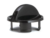 A black plastic automotive fastener, featuring a domed top with a small tab, circular base, and three prongs extending downward for securing into a panel or hole. Made in USA, its smooth and shiny surface has small notches visible at the bottom.