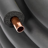 A close-up of a copper RC20 tubing partially encased in black foam insulation. The spongy foam surrounds the shiny pipe, ideal for CVDF condensing units. In the background, more black insulated piping coils—perfect for 20 ft. length installations.
