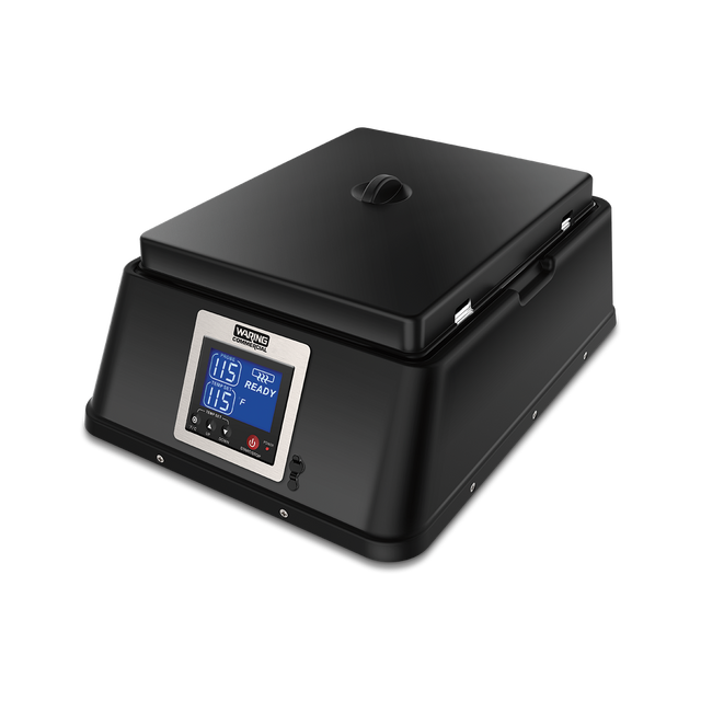 A black, rectangular countertop chocolate melter with a hinged lid and a digital control panel on the front. The panel displays temperature and time settings in blue light, with several buttons below. The appliance sits on a plain white background.
