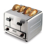 A stainless steel 4 slice toaster with two control knobs and two levers on the front. Four thick slices of bread are partially toasted and visible in each slot. The toaster is labeled “Waring Heavy Duty Toaster.”.