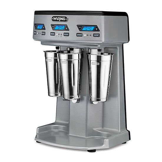 A commercial Waring WDM360TX Triple Spindle Drink Mixer with three stainless steel mixing cups, digital timers, blue LED displays, and black start/stop buttons on a sleek gray metallic base. The robust machine stands confidently on four small feet.