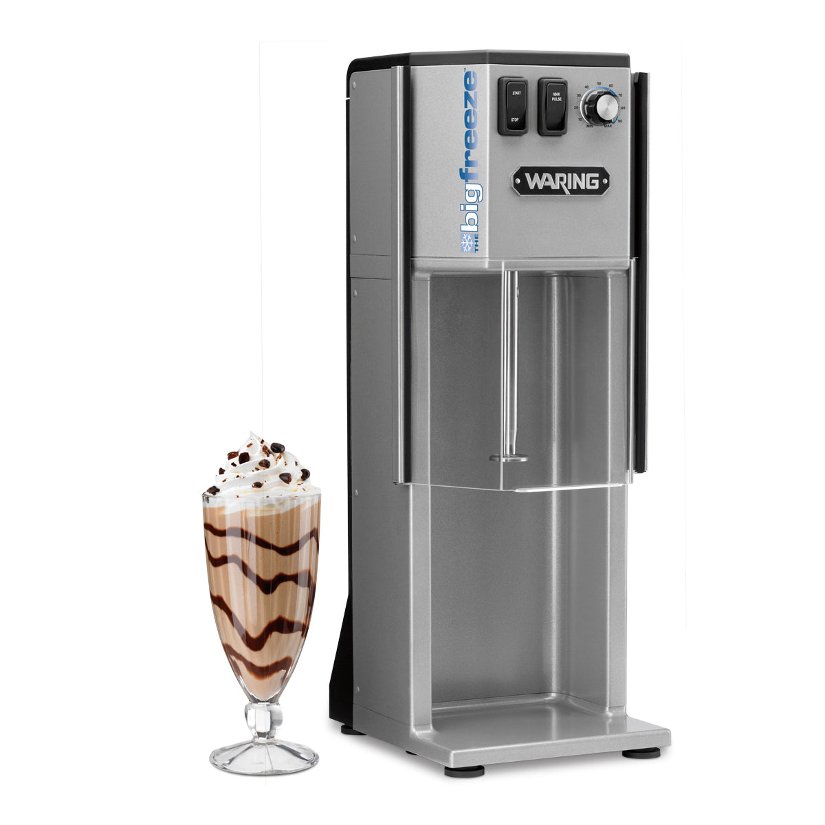 A tall, silver Waring WDM500 frozen drink machine stands upright. To its left is a glass filled with a milkshake, topped with whipped cream, chocolate drizzle, and chocolate chips. The machine features buttons, a spout, and a solid agitator for mixing.