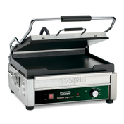 A stainless steel Waring commercial panini grill with a partially open ribbed top plate, flat cast iron cooking surface, black handle, side handles, and a front control panel featuring an adjustable thermostat and labeled Waring Tostato Supremo.
