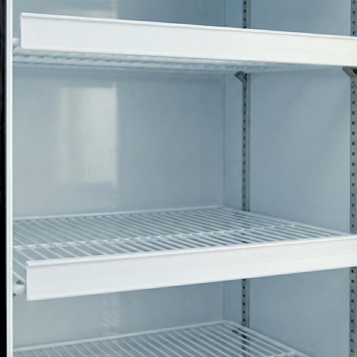 A close-up of an empty commercial refrigerator, model EGM-13W, with three white wire shelves and a clean, glossy interior. The shelves are evenly spaced, and the fridge door is open—perfect for displaying Empura Parts or a price tag set.