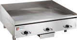 A commercial electric griddle featuring three black control knobs, raised side and back splashes, and a small Wolf brand logo on the front left corner. This stainless steel griddle offers a flat cooking surface with a grease tray beneath the front edge.