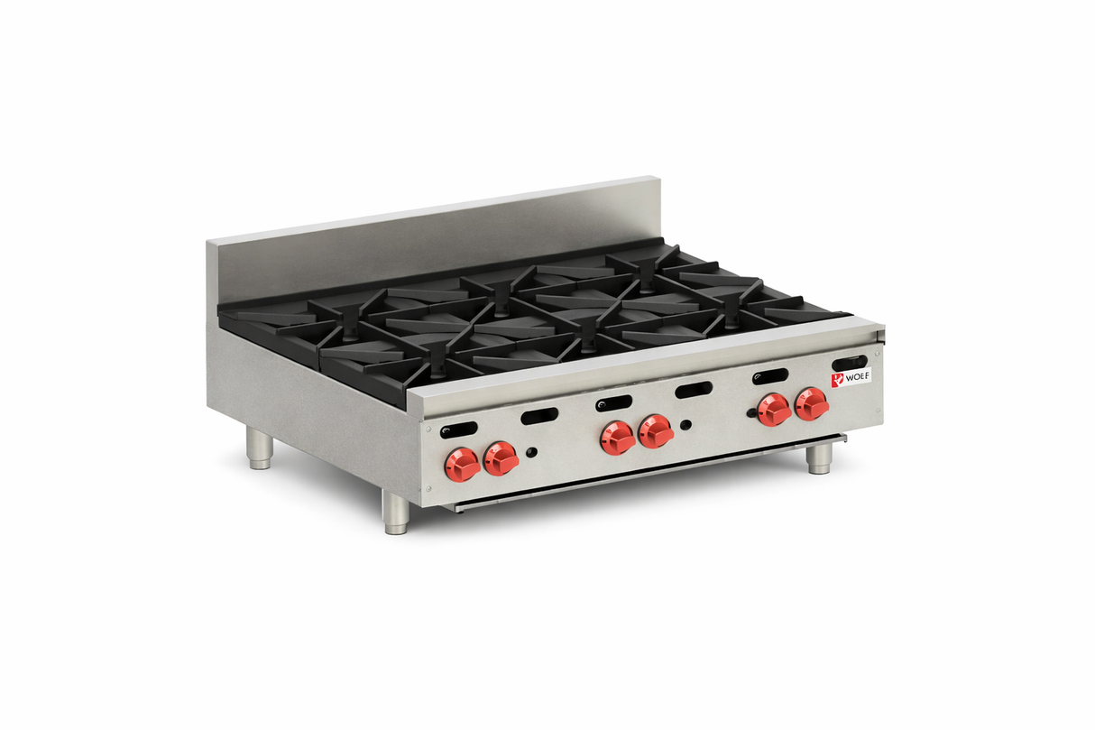 A commercial stainless steel countertop gas hotplate with four black cast iron burners, four red control knobs, a front panel with indicator lights, and a metal backsplash, resting on four short legs on a white background.