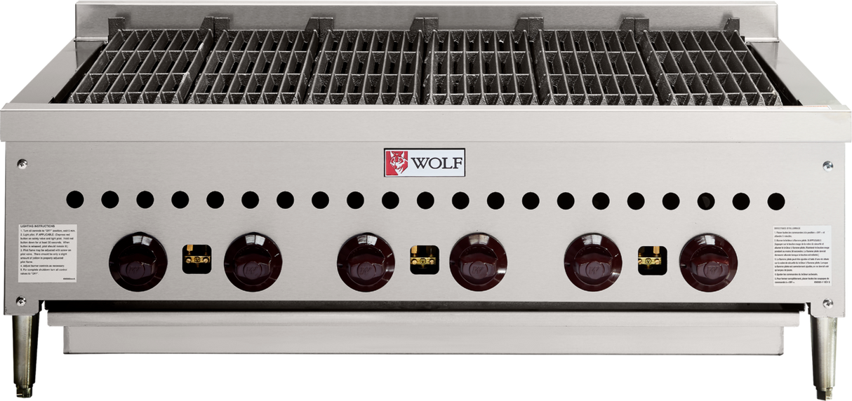 A commercial gas charbroiler with six red control knobs, stainless steel body, vented front panel, black grates, and the Wolf logo at the center. Ideal for professional kitchen grilling and built for heavy-duty use on sturdy short legs.