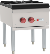 A commercial stock pot range with a stainless steel exterior, featuring two burners each controlled by a large red knob. This gas kitchen appliance stands on four metal legs and displays the “Wolf” logo beneath the control panel.