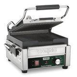 A compact panini grill with ribbed cast iron plates, featuring a stainless steel body, black handle, control panel with power switch, temperature dial, indicator lights, and the Waring Panini Perfetto branding on the front.