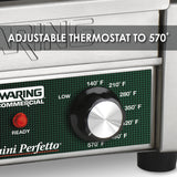 A close-up of a compact panini grill shows a temperature control knob with settings from 140°F to 570°F. Text on the image reads “ADJUSTABLE THERMOSTAT TO 570°.” The green panel features metallic accents, ribbed cast iron plates, and a “Ready” light.