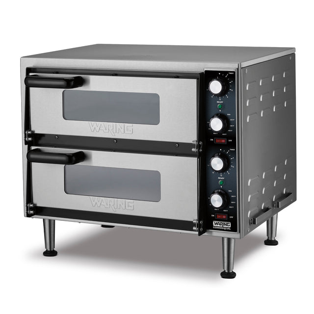 A stainless steel double-deck pizza oven with black handles, glass windows on both doors, control knobs, and indicator lights on the right side panel. This electric pizza oven stands on four metal legs and features the Waring brand on the doors and base.