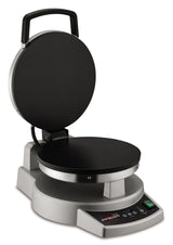 A silver and black multipurpose cooktop with an open lid, round nonstick cooking surfaces, a handle on the top, control buttons, a green power switch, and a digital display. This versatile device sits on a flat surface, ready for use.