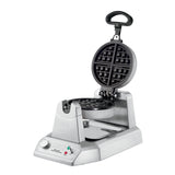 This heavy-duty Belgian Waffle Maker features a round, nonstick plate that opens vertically. Its stainless steel base includes a control dial, indicator lights, Waring Pro branding, and a drip tray—ideal for international use.
