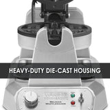 A silver Belgian Waffle Maker with round, non-stick plates is shown. The text HEAVY-DUTY DIE-CAST HOUSING overlays the image. The control panel features a knob, indicator lights labeled “Ready” and “Power,” and product branding.