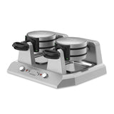 A Commercial Belgian Waffle Maker featuring non-stick plates, independent controls, stainless steel build, two round waffle plates, black handles, indicator lights, and control knobs on a sturdy base. The brand logo is visible on the front.