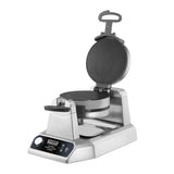 A commercial double waffle maker with stainless steel housing and black non-stick plates is shown open. It features a control knob, digital display, and a rotating handle, making it ideal as a waffle cone maker for busy kitchens.